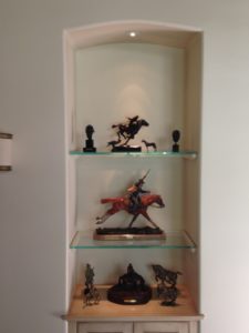 Illuminated display alcove with glass shelves and accent lighting