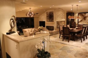 Open-concept living and dining room with sputnik chandelier and stone fireplace