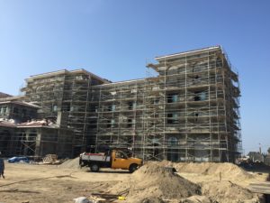 Large multi-story building wrapped in scaffolding during construction