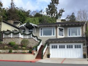 Craftsman home with holiday string lighting along the rooflines