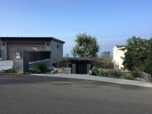 Modern hillside home with concrete facade and drought-tolerant landscaping