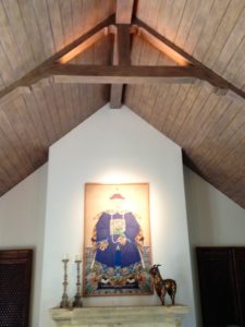 Wood-beam vaulted ceiling with accent lighting over a fireplace