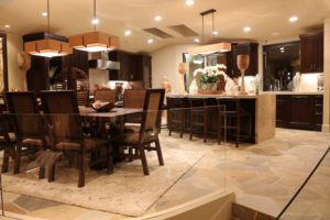Dark-wood kitchen and dining area with pendant lights over island
